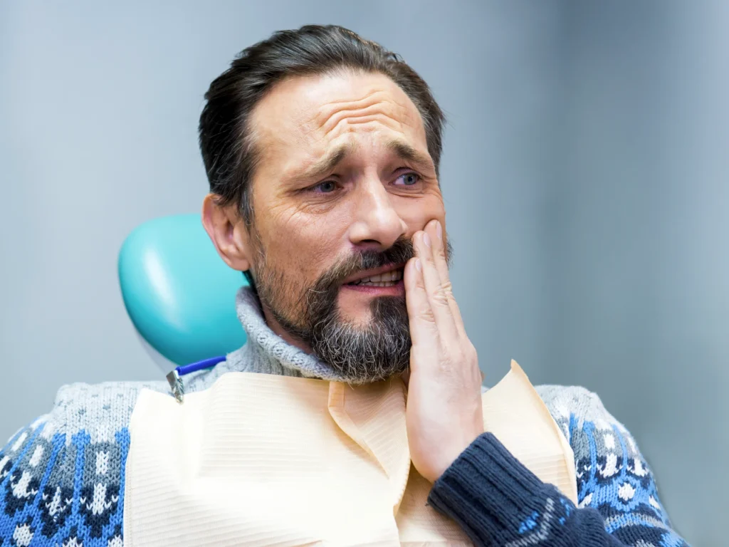 man visiting an emergency dentist with tooth pain